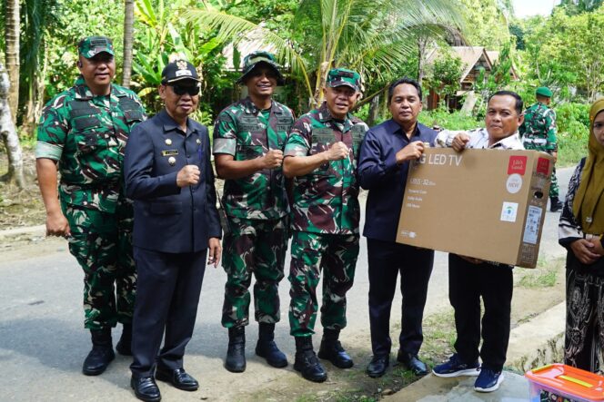 
 Wakil Ketua I DPRD Kabupaten HSS Husnan menyerahkan bantuan dalam program TMMD. (Kominfo HSS)